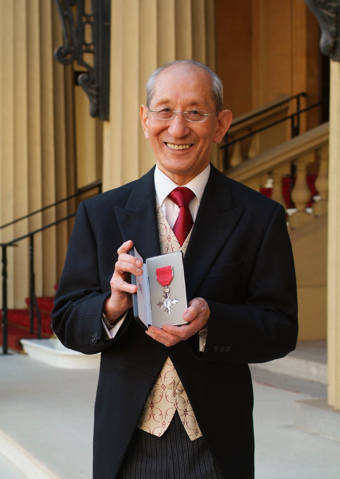 Maître Harada devant Buckingham Palace, tenant sa médaille MBE dans son écrin, octobre 2007